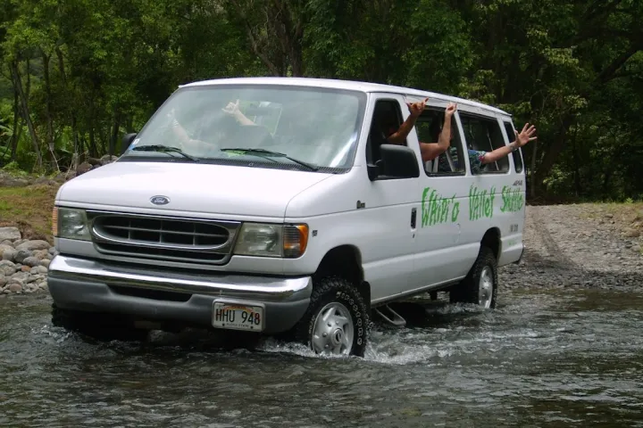 a car parked on pavement near a forest